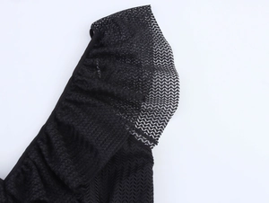 Detailed macro view of black mesh lace fabric texture and ruffled hemline on elegant dress