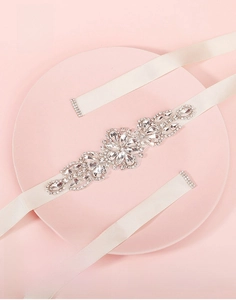 Detailed view of rhinestone bridal belt with floral crystal applique on ivory satin ribbon