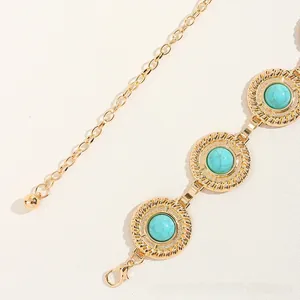 Detailed close-up of vintage gold waist chain with turquoise stone and lobster clasp