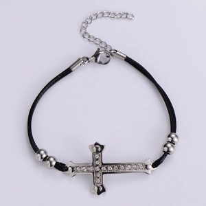 Detailed view of black braided cord bracelet with rhinestone cross pendant and lobster clasp