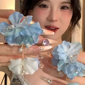 Detail of light blue floral tassel earrings with mesh petals and hanging pearls