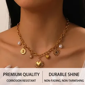 Détails d'un collier à grosse chaîne dorée avec des breloques en perles, soleil et cœur