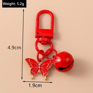 Detailed view of red metal butterfly keychain with bell including size and weight specs