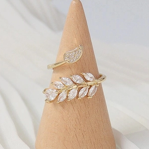 Macro detail of leaf-shaped ring featuring sparkling marquise cubic zirconia on wood stand