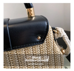 Détail du sac en paille avec rabat en cuir noir, ferrures dorées et bandoulière corde
