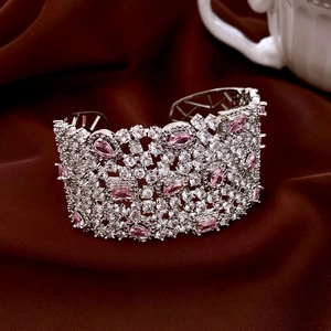 Retro hollow cuff bracelet featuring pink zircons on a dark silk background