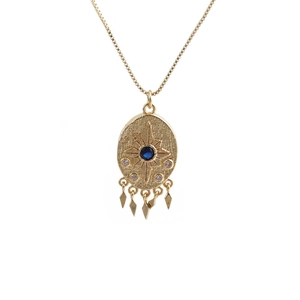 Detail of gold starburst necklace with blue gem center and five diamond tassels