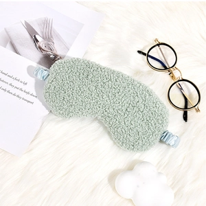 Detail of light green faux teddy fur sleep mask with smooth blue silk elastic strap