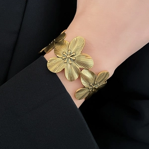 Close-up of vintage gold flower bracelet on wrist with elegant metal floral textures