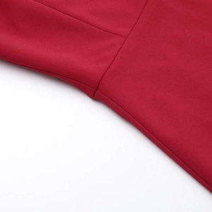 Détail montrant les coutures fines et la texture lisse du tissu de la robe de soirée rouge