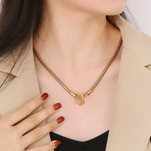 Collana a catena serpente dorata con chiusura a cuore indossata da una modella