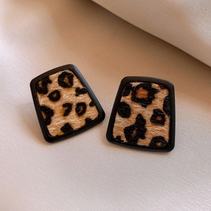 Macro shot of leopard print trapezoid earrings with plush texture and black border details