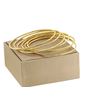 Set of 7 gold stackable stainless steel bangles with textured diamond cut finish