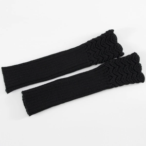 Macro shot of black knitted arm warmer with textured fish scale wave pattern detail