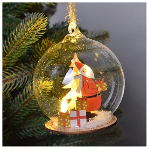 Close-up of a festive Christmas glass ball with LED lights and a wooden Santa scene