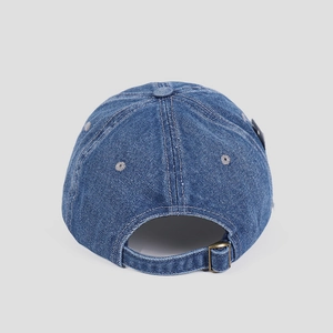 Detail of adjustable metal buckle and breathable eyelets on blue denim baseball cap