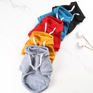 Detail view of five colorful fleece pet hoodies with drawstrings on marble surface