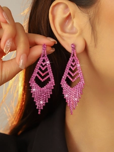 Detail showing long pink rhinestone tassel earrings with rhombus design on model
