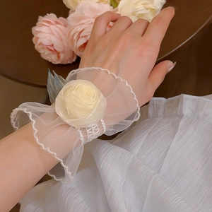 Détail d'un bracelet fleur rose crème avec dentelle et feuilles bleues élégantes