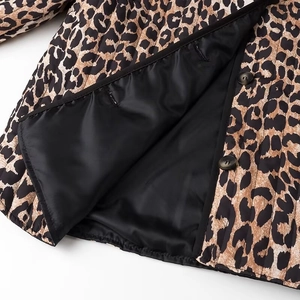 Detail of leopard print quilted jacket showing a dark button and soft black inner lining