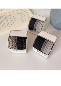 Detail of high-elasticity braided hair ties in neutral black, grey and beige tones