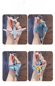 Detail view of four colorful mini fighter jet keychains with metal rings and clips