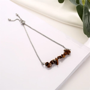 Detail of adjustable silver chain bracelet with brown tiger eye stone beads on satin