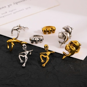 Macro view of gothic skull and dolphin ear cuffs set in gold and silver finish