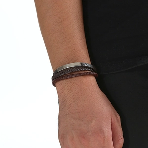 Close-up of a multi-layer woven leather bracelet with a magnetic steel clasp for men