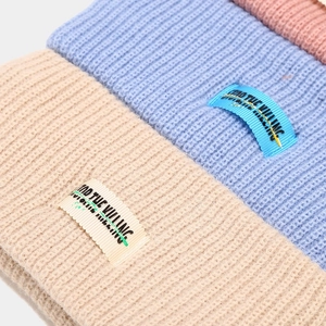 Thick knit sports headbands in beige, blue and pink with stylish lettered woven labels