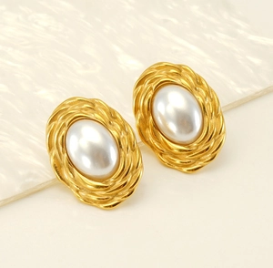 Detailed macro view of gold-plated woven oval frame with glossy artificial pearl