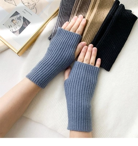 Detailed close-up of ribbed knit fingerless gloves in blue, grey, brown, and black colors