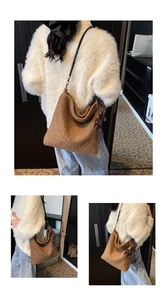 Detail view of a brown plush shoulder bag with black strap and dog charm accessory