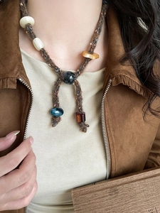 Detailed macro shot of bohemian braided cord necklace with assorted resin and glass beads