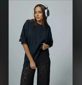 Close-up of vintage wash black oversized t-shirt with distressed holes and lace trousers