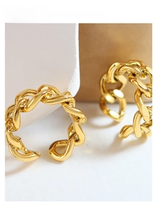 Macro detail of golden cuban link chain ring with a high-polished finish and open band