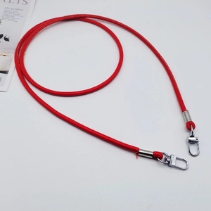 Close-up of red PU leather shoulder strap with silver metal spring clasps on white background