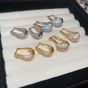 Gros plan de boucles d'oreilles créoles en U or et argent serties de zircons en écrin