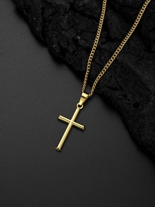 Gros plan d'un collier pendentif croix dorée sur fond de charbon noir texturé