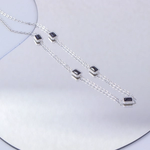 Macro shot of silver titanium steel necklace featuring rectangular black zircon stones