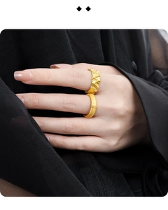 Detailed macro view of two gold rings showing irregular wave texture and matte finish detail