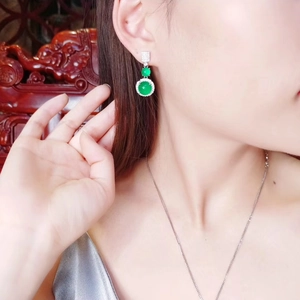 Close-up of green chalcedony earrings with silver diamond halo worn by model