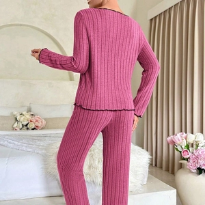 Women's rose red rib-knit pajama set with black lettuce edge trim, bedroom view