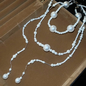 Detail of multi-layer pearl necklace on brown velvet display with elegant silver links