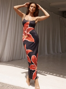 Close-up of elegant black floral maxi dress featuring red flower print and slim shoulder straps