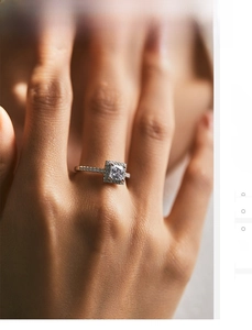 Macro shot of s925 silver square halo ring with side diamonds on model hand
