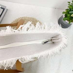 Large cream canvas tote bag with white tassel trim and brown leather straps