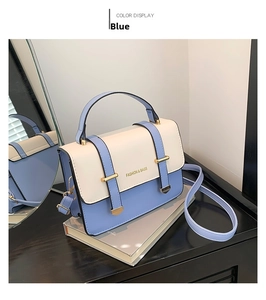 Detail of color-block PU leather bag featuring gold buckle and adjustable strap
