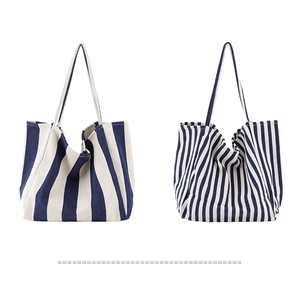 Detail view of canvas tote bags showing side-by-side wide and thin blue stripes texture