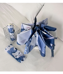 Detail of blue and white cat print umbrella with matching portable storage bag